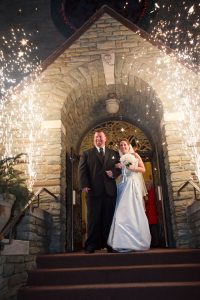 A bride and groom walk through close proximate fireworks set up by a NJ fireworks company.